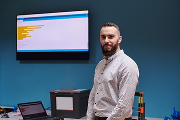 Image showing A bearded man in a modern robotics laboratory, immersed in research and surrounded by advanced technology and equipment.