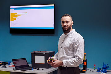 Image showing A bearded man in a modern robotics laboratory, immersed in research and surrounded by advanced technology and equipment.