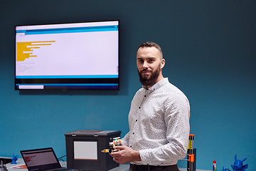 Image showing A bearded man in a modern robotics laboratory, immersed in research and surrounded by advanced technology and equipment.