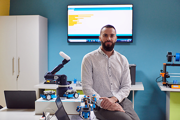 Image showing A bearded man in a modern robotics laboratory, immersed in research and surrounded by advanced technology and equipment.