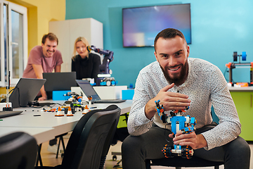 Image showing A bearded man in a modern robotics laboratory, immersed in research and surrounded by advanced technology and equipment.