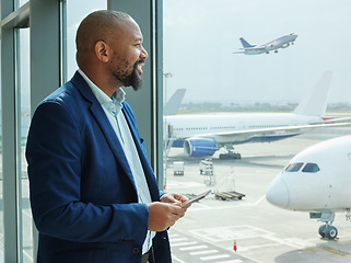 Image showing Black man at airport, smartphone and travel with communication, airplane and smile for business trip. Looking out the window, waiting for flight with transportation, journey and airline with mobile
