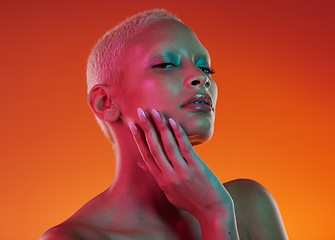 Image showing Skincare, beauty and portrait woman with neon face makeup and light in creative advertising on orange background. Cyberpunk, art and model isolated for skin care and futuristic mockup space in studio