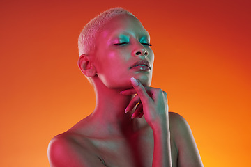 Image showing Skincare, beauty and eyes closed, woman with neon makeup and light for creative advertising on orange background. Cyberpunk, art and model isolated for skin care and futuristic mockup space in studio