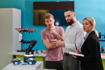 Image showing A group of students working together in a laboratory, dedicated to exploring the aerodynamic capabilities of a drone