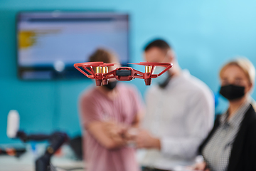 Image showing A group of students working together in a laboratory, dedicated to exploring the aerodynamic capabilities of a drone