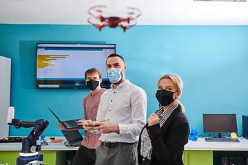 Image showing A group of students working together in a laboratory, dedicated to exploring the aerodynamic capabilities of a drone