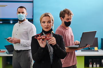 Image showing A group of students working together in a laboratory, dedicated to exploring the aerodynamic capabilities of a drone