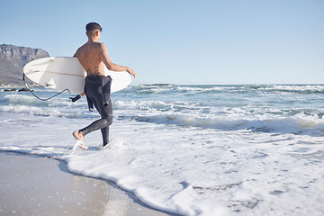 Image showing Surfing, man and walking in waves, sea and ocean of summer, freedom and blue sky mockup in Cape Town. Surfer guy, board and swimming in water, beach and relax on holiday, travel or sunshine adventure