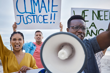 Image showing Climate change sign, protest and black man with megaphone for freedom movement. Angry, crowd screaming and young people by the sea with world support for global, social and equality action at beach