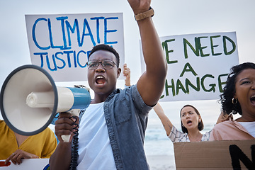 Image showing Climate change poster, protest and black man with megaphone for freedom movement. Angry, crowd screaming and young people by the sea with world support for global, social and equality action at beach