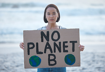 Image showing Protest, planet earth and woman with a sign for climate change to stop pollution and global warming at beach. Political, nature activism and portrait of Asian female with board by ocean for march