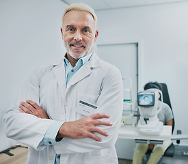 Image showing Man, portrait and smile of optometrist with arms crossed in hospital or medical clinic for eye care. Healthcare, vision or happy, confident or proud senior male ophthalmologist or doctor of optometry