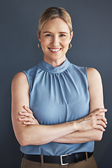 Image showing Portrait, smile and business woman with arms crossed in studio isolated on a blue background. Ceo, boss and happy, confident and proud female entrepreneur from Canada with vision and success mindset.