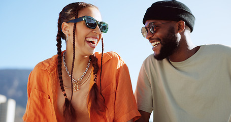 Image showing Friendship, flirting and couple with sunglasses in city sitting on building rooftop laughing. Love, friends and romance, urban dating and freedom for gen z woman and man with smile on crazy fun date.