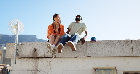 Image showing Love, friendship and a couple sitting on rooftop of city building in summer time. Diversity, friends and romance, gen z urban dating for happy woman and black man with smile and skateboard on date.