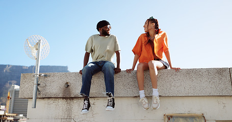 Image showing Friends, happiness on city building rooftop together talking, conversation and laughing, urban lifestyle. Couple, man and woman do cool greeting sitting outdoor to relax with cityscape