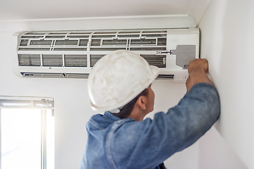 Image showing Air conditioner, ac repair and building hvac maintenance of a handyman and builder on home renovation. Electric technician, service worker and contractor in a house for equipment installation on wall