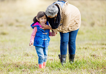 Image showing Grandmother, happy girl and nature walk of a kid with senior woman in the countryside. Outdoor field, grass and elderly female with child on a family adventure on vacation with happiness and fun