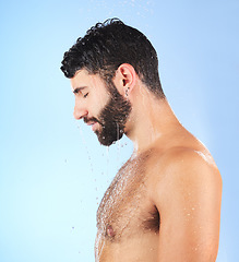 Image showing Man, shower and profile of a model in water for cleaning, skincare and hygiene wellness. Isolated, blue background and studio with a young person in bathroom for dermatology and self care routine