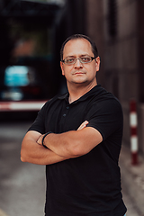 Image showing A successful businessman with crossed arms, posing outdoors