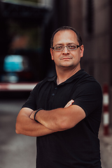 Image showing A successful businessman with crossed arms, posing outdoors