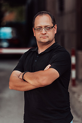 Image showing A successful businessman with crossed arms, posing outdoors