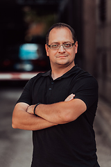 Image showing A successful businessman with crossed arms, posing outdoors