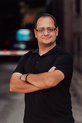 Image showing A successful businessman with crossed arms, posing outdoors