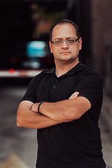 Image showing A successful businessman with crossed arms, posing outdoors