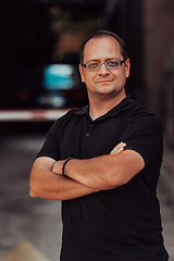 Image showing A successful businessman with crossed arms, posing outdoors