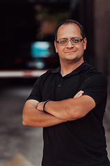 Image showing A successful businessman with crossed arms, posing outdoors