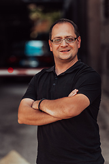 Image showing A successful businessman with crossed arms, posing outdoors