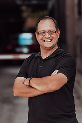 Image showing A successful businessman with crossed arms, posing outdoors