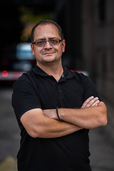 Image showing A successful businessman with crossed arms, posing outdoors