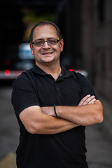 Image showing A successful businessman with crossed arms, posing outdoors