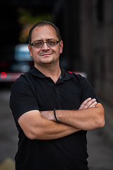 Image showing A successful businessman with crossed arms, posing outdoors