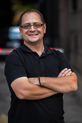 Image showing A successful businessman with crossed arms, posing outdoors