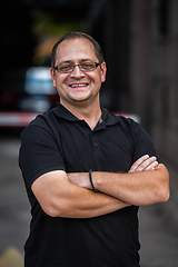 Image showing A successful businessman with crossed arms, posing outdoors