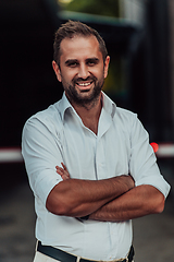 Image showing A successful businessman in a white shirt with crossed arms posing outdoors