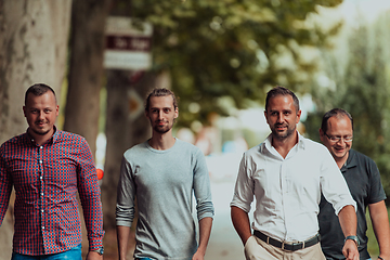 Image showing After a productive day at work, a group of diverse colleagues enjoy a leisurely stroll through a modern and natural urban setting