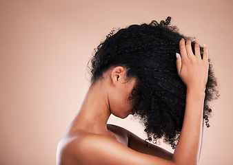 Image showing Hair care, touching and a woman styling curls isolated on a brown background in a studio. Salon, cosmetic and model feeling a hairstyle for volume, touchup and style for an afro on a backdrop