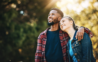 Image showing Love, interracial and couple in nature, freedom and happiness with romance, carefree and bonding together. Romantic, black man and woman hug, loving and outdoor for fun, relationship and cheerful