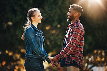 Image showing Love, date and interracial couple holding hands in nature for a walk, romamce and gratitude. Support, trust and black man with a woman, affection and walking in marriage in a park in Germany