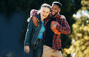 Image showing Love, diversity couple and laughing in nature, having fun and playing football outdoors. Comic, interracial romance and happy black man and woman hug, laugh at funny joke and enjoying time together.