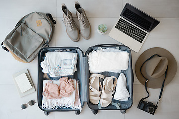 Image showing Travel, suitcase and laptop with camera for vacation or holiday with online booking on floor. Above luggage, clothes and shoes while planning for summer photography journey motivation or inspiration