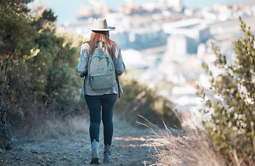 Image showing Woman hiking, travel and trekking in nature park, adventure and fitness outdoor with backpack and exercise. Female hiker on trail, back view and walking with healthy active lifestyle and fresh air