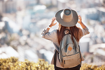 Image showing Woman back, mountain and cityscape view for hiking, travel and nature for holiday, summer and wellness goal. Girl, explorer and mountains with city skyline, buildings and looking in morning sunshine