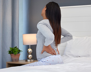 Image showing Tired, burnout and pregnant woman with back pain on a bed for rest, injury and fatigue. Healthcare, stress and girl with backache during pregnancy in her bedroom with morning sickness and cramps