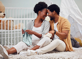 Image showing Love, laundry and black couple getting ready for a baby, folding clothes and preparation in pregnancy. Happy, parents and pregnant woman and man sitting with clothing for child, affection and relax